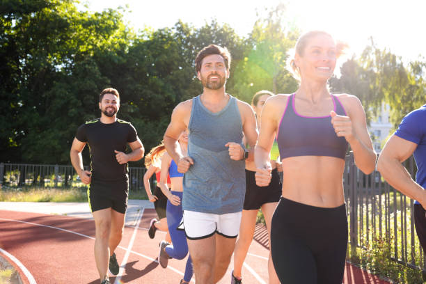 istock Group of people running at stadium on sunny day 1932570690