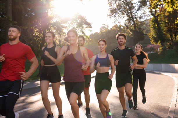 istock Group of people running outdoors on sunny day 1932570728