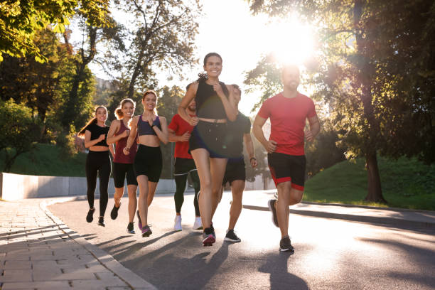 istock Group of people running outdoors on sunny day 1932570730