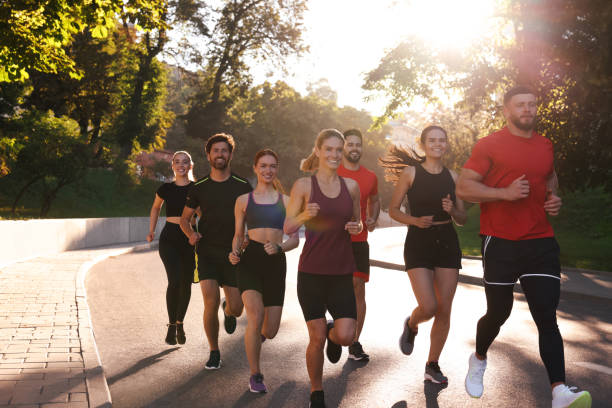 istock Group of people running outdoors on sunny day 1932571259