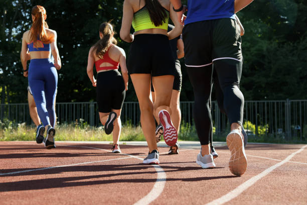 istock Group of people running at stadium on sunny day, back view 1932571273