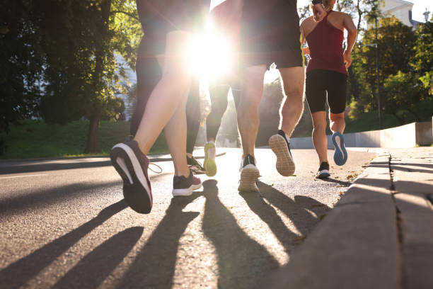istock Group of people running outdoors on sunny day, back view 1932571274