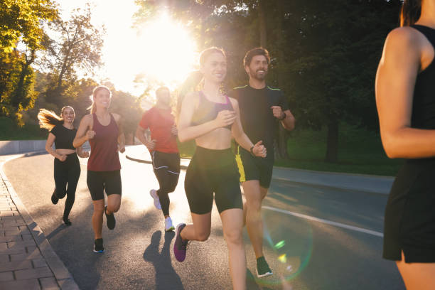 istock Group of people running outdoors on sunny day 1932572312