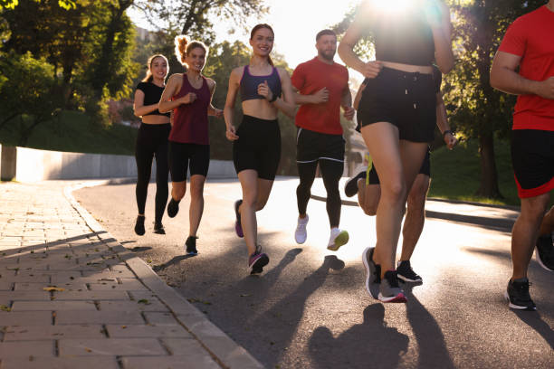 istock Group of people running outdoors on sunny day 1932572432