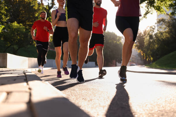 istock Group of people running outdoors on sunny day 1932572670