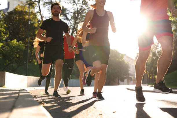 istock Group of people running outdoors on sunny day 1932573421