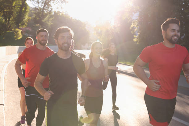 istock Group of people running outdoors on sunny day 1932573928