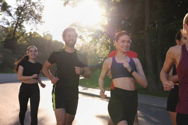 istock Group of people running outdoors on sunny day 1932573941
