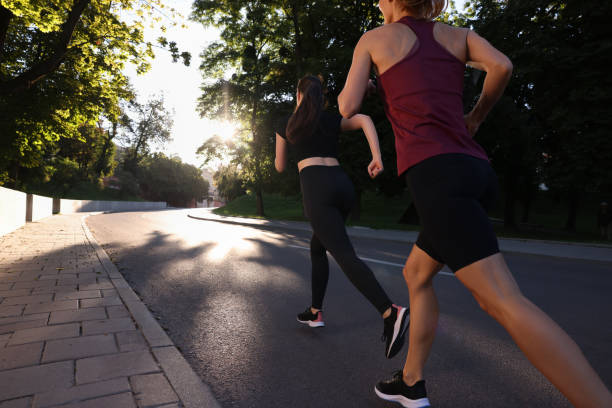 晴れた日に屋外を走る女性、後ろ姿 - jogging group of people park running ストックフォトと画像