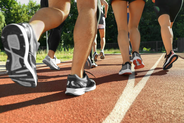 istock Group of people running at stadium on sunny day, closeup 1932574510