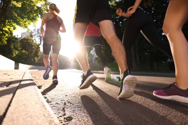 istock Group of people running outdoors on sunny day, back view 1932575022