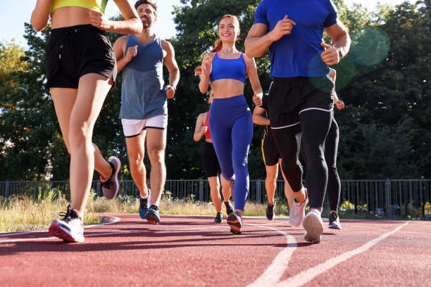 istock Group of people running at stadium on sunny day 1932580648