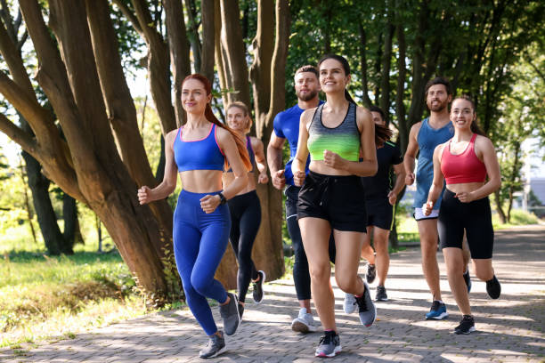istock Group of people running in park on sunny day 1932580866