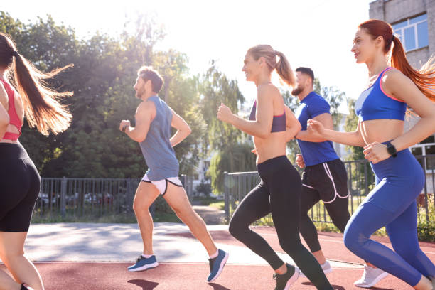 istock Group of people running at stadium on sunny day 1932580872