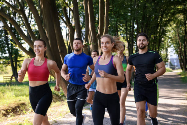 istock Group of people running in park on sunny day 1932581406