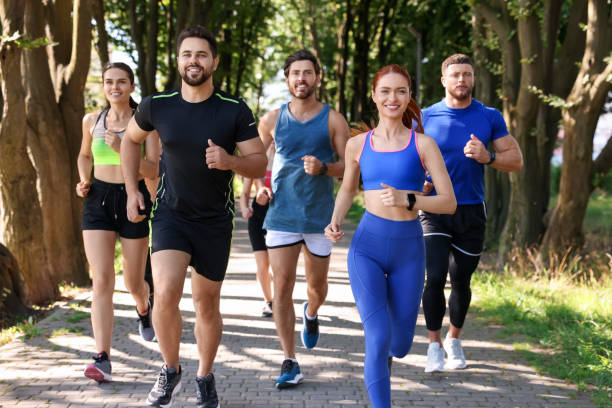 istock Group of people running in park on sunny day 1932581407