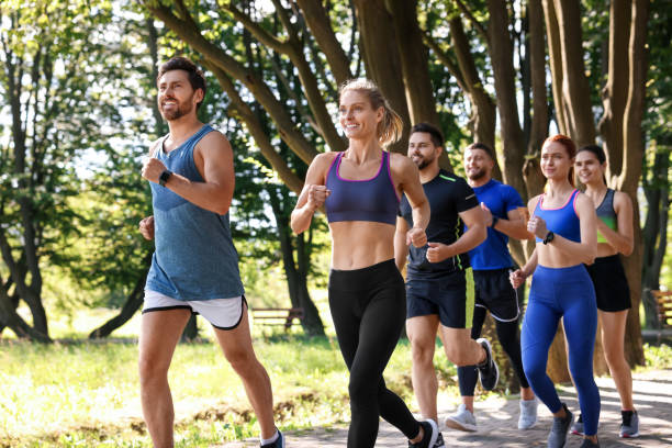 istock Group of people running in park on sunny day 1932581425