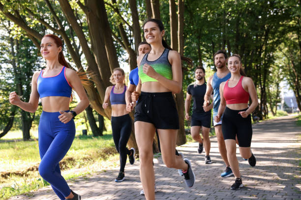 istock Group of people running in park on sunny day 1932581429