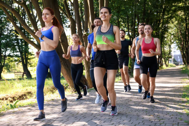 istock Group of people running in park on sunny day 1932581942