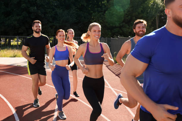 istock Group of people running at stadium on sunny day 1932581978