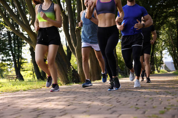 istock Group of people running in park, closeup 1932581981