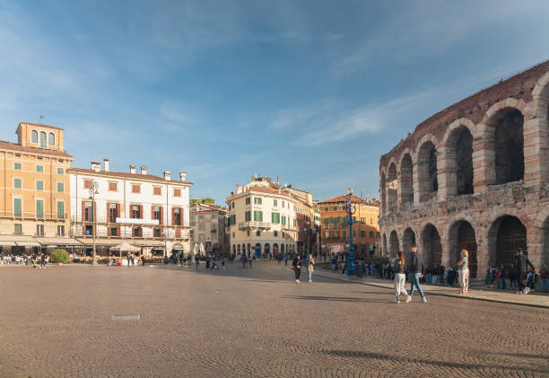 Verona, Italy - 2022, October 30 - People walking in the square called Piazza Bra next to the Arena, an ancient Roman amphitheatre