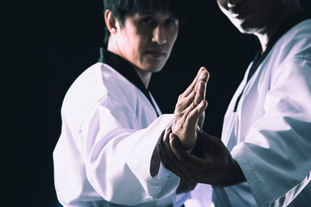 istock Taekwondo Training Two-Man Poses checking on black background close up 1932601103