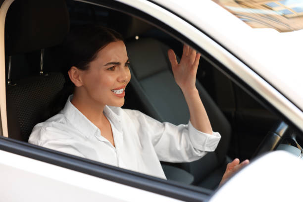 istock Stuck in traffic jam. Angry driver in her car, view from outside 1932634940