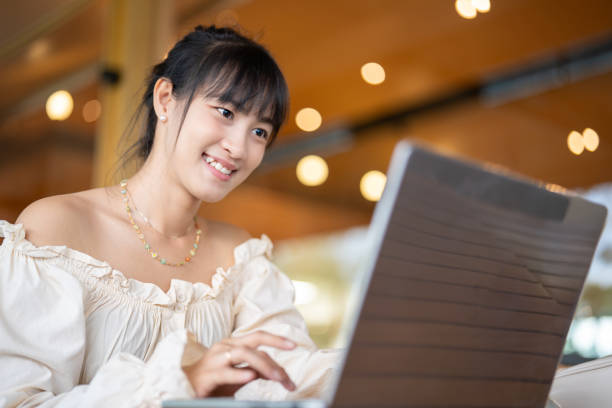 istock Young Asian Woman's Remote Office in coffee shop. 1932636524