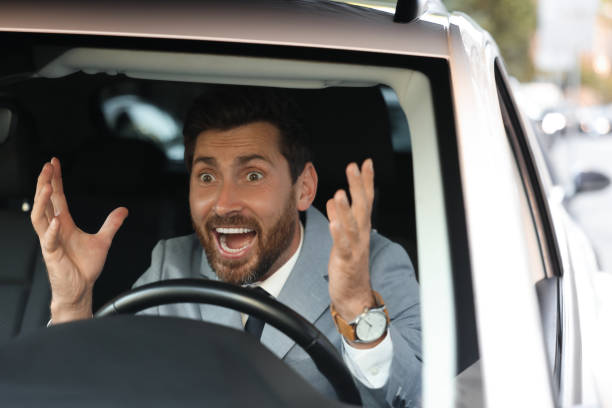 istock Angry driver screaming in his car, view through windshield. Stuck in traffic jam 1932637053
