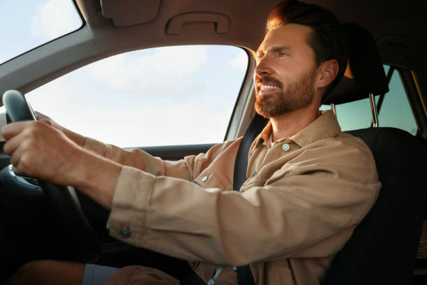 istock Happy man sitting in his car, low angle view. Enjoying trip 1932638681