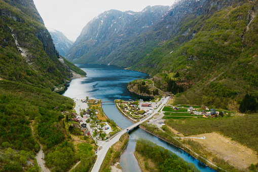 Drone high-angle photo of beautiful summer green mountain valley with cars on highway and the authentic Norwegian village in Nærøyfjord, Western Norway, Scandinavia
