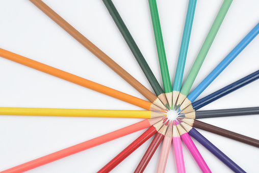 A group of seamless coloured pencils lying in circle photographed on white background