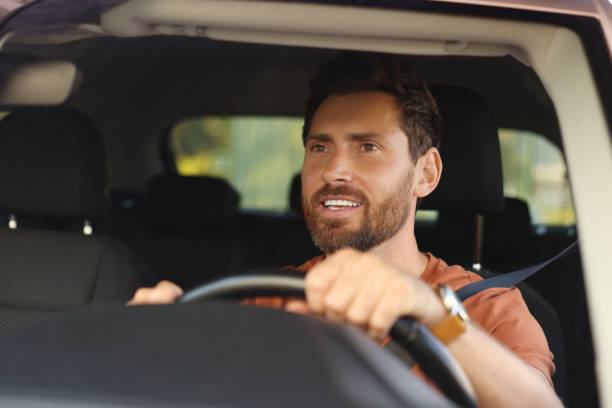 istock Enjoying trip. Happy bearded man driving car, view through windshield 1932661798