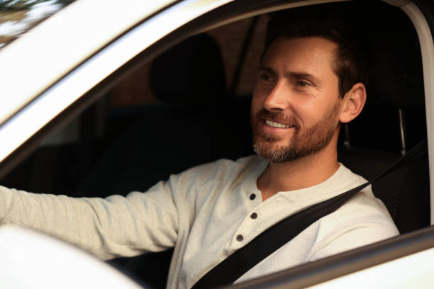 istock Enjoying trip. Happy bearded man driving his car, view from outside 1932662366