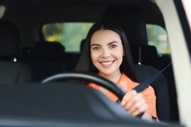 istock Enjoying trip. Happy young woman driving her car, view through windshield 1932662902