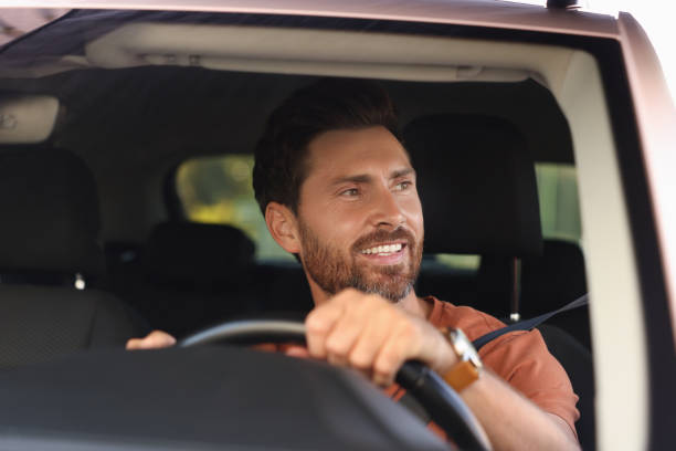 istock Enjoying trip. Happy bearded man driving car, view through windshield 1932663478