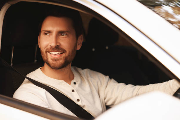 istock Enjoying trip. Happy bearded man driving his car, view from outside 1932663986
