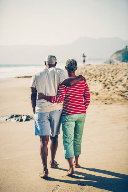 istock Senior African American couple walking embraced on beach 1932690288
