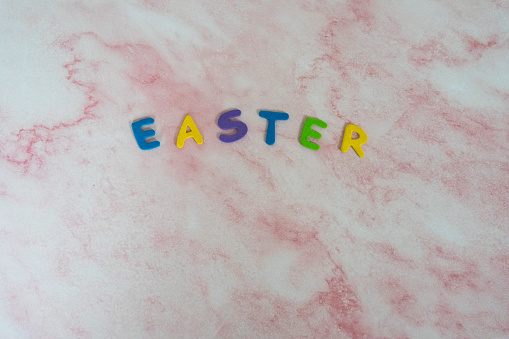 Easter in colorful letters on a pink marble background