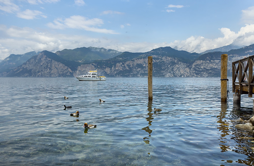 Beautiful boat on Lake Garda against the backdrop of mountains, Italy