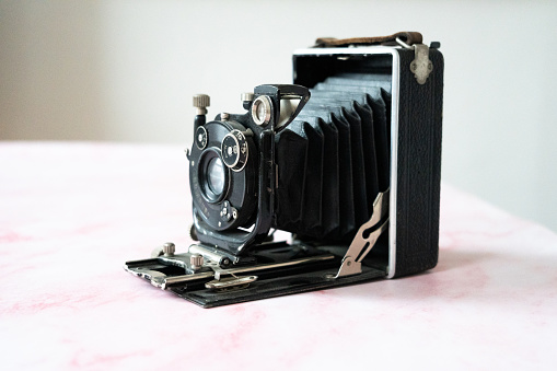 A woman adjusting settings of a vintage photo camera