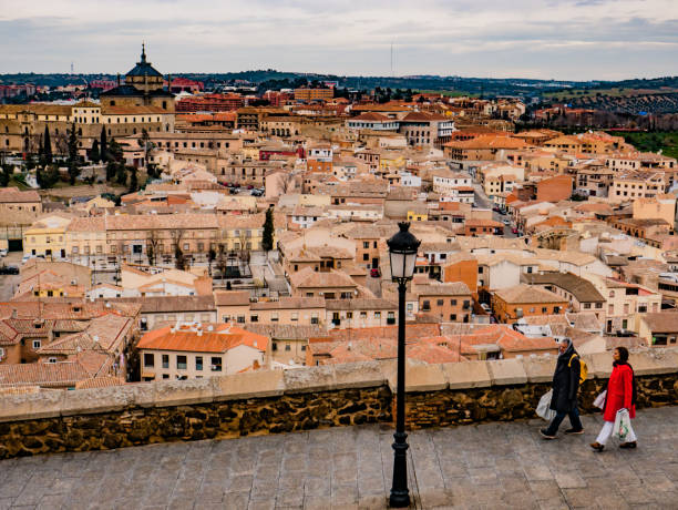 Toledo, Spain, January 13, 2023: People walking outside on the street in Toledo, an ancient city located on a hill above the plains of Castilla-La Mancha, in central Spain. It is the capital of the region and is known for the medieval Arab, Jewish and Christian monuments in its ancient walled city.
