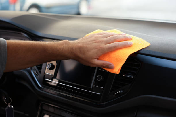 istock Man cleaning center console with rag in car, closeup 1932714108