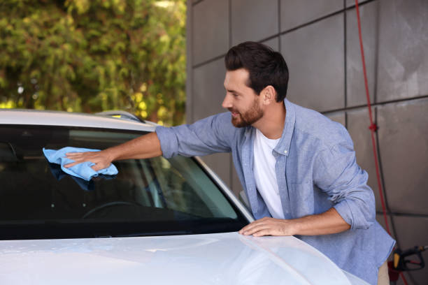 istock Bearded man cleaning car windshield with rag outdoors 1932714111