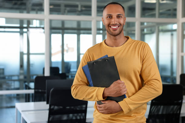 istock Happy man with clipboards in office, space for text 1932737972