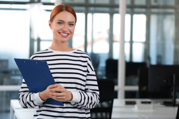 istock Happy woman clipboard in office, space for text 1932738514
