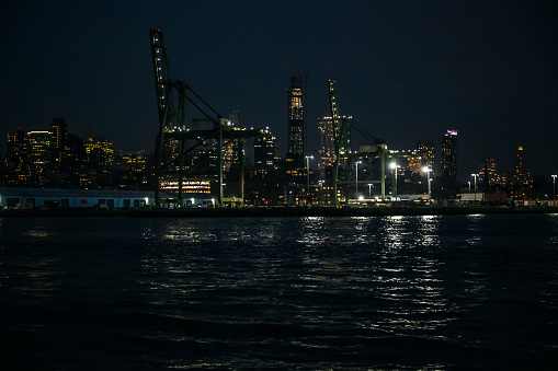 Brooklyn harbor at night from Hudson bay, Red Hook, New YorkRed Hook old pier buildings with night lights and reflection in water, Brooklyn, New York