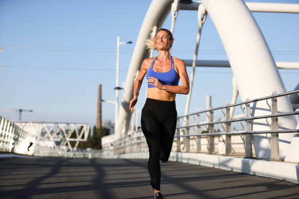 istock Happy blond woman running front view 1932770651