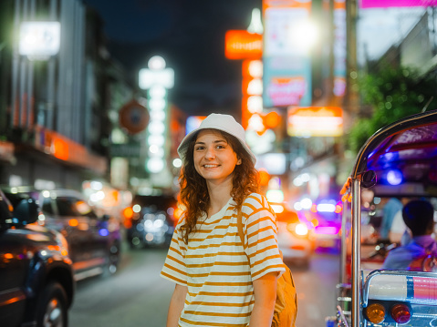 Young Caucasian woman exploring Chinatown in Bangkok, Thailand at night